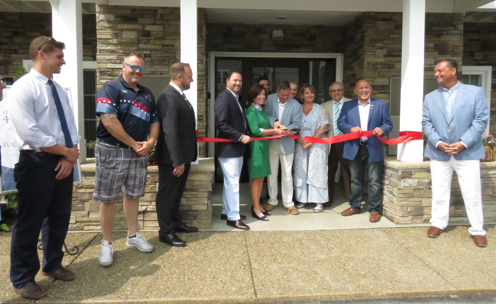 Local and state officials stand by Lou Visone as he cuts the ribbon to 600 River Road Apartments. (Photos by David Yarger) 
